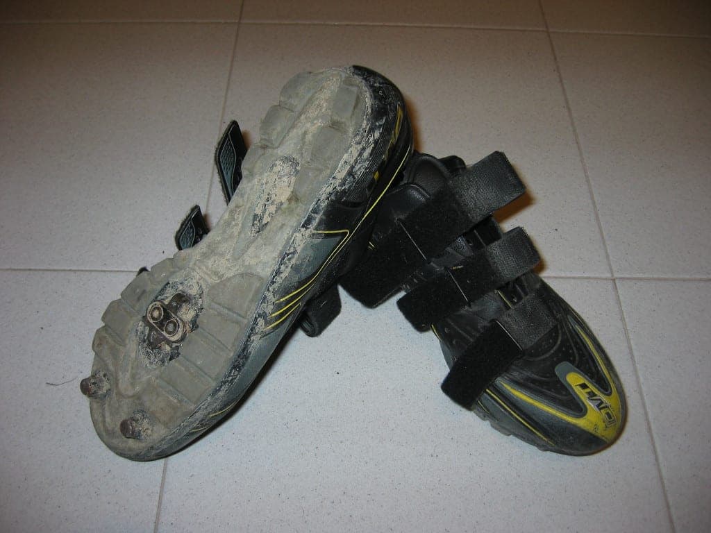 A pair of cycling shoes showing the cleats on the soles for clipless pedals.