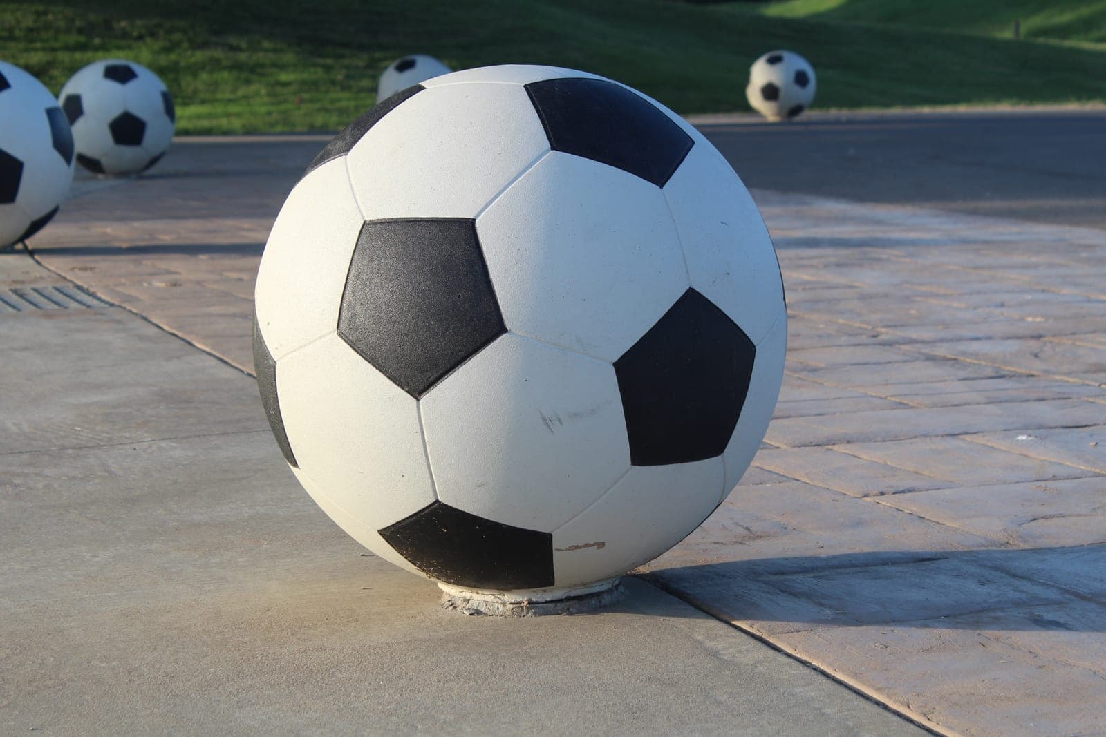 A classic black-and-white football (soccer ball) on pavement.