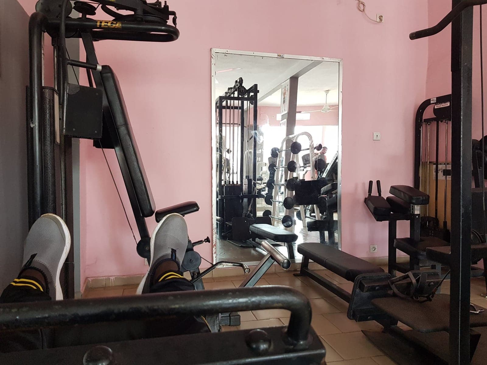 The interior of a gym with weight machines and benches.