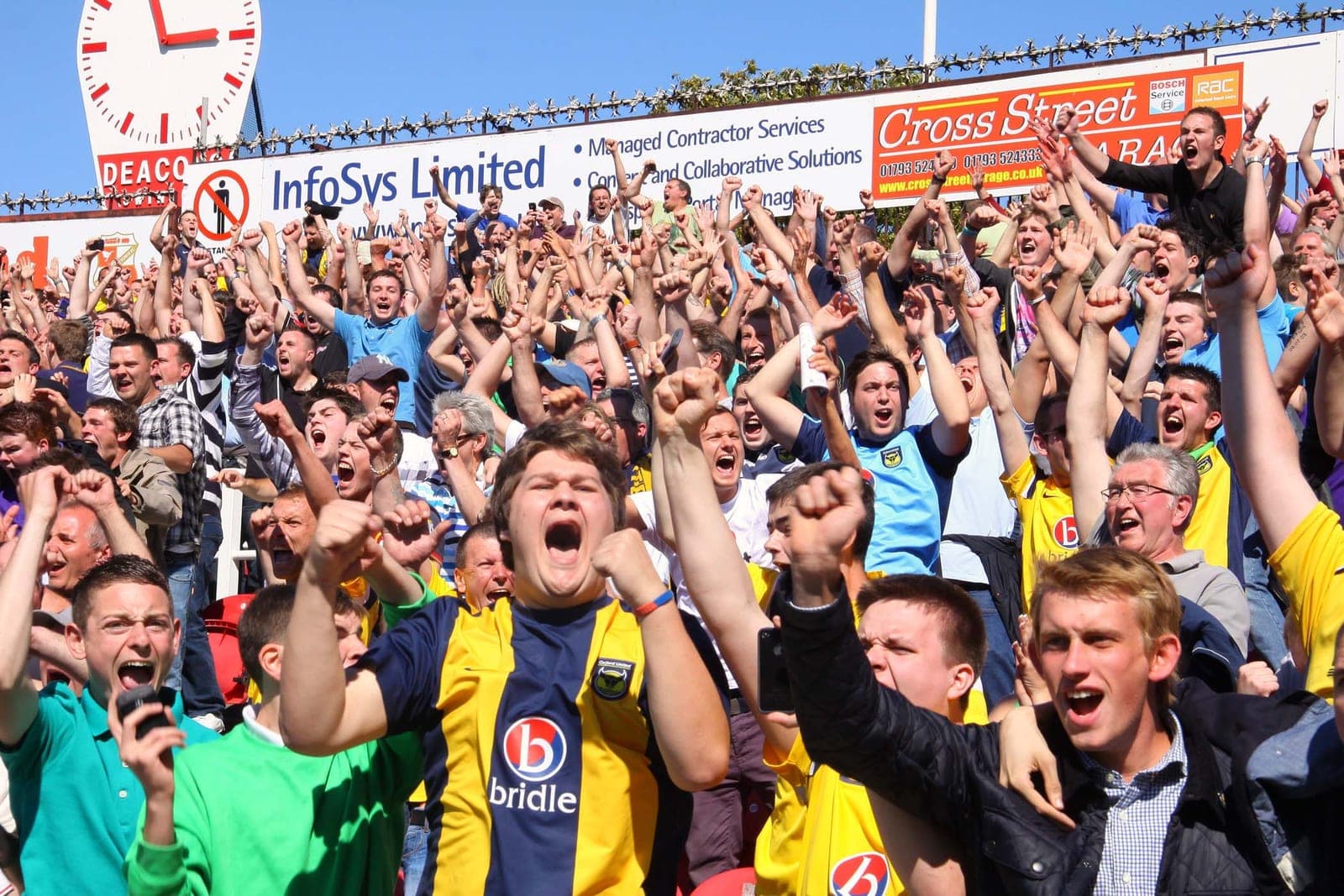 Football supporters celebrate jubilantly in the stands during a match.