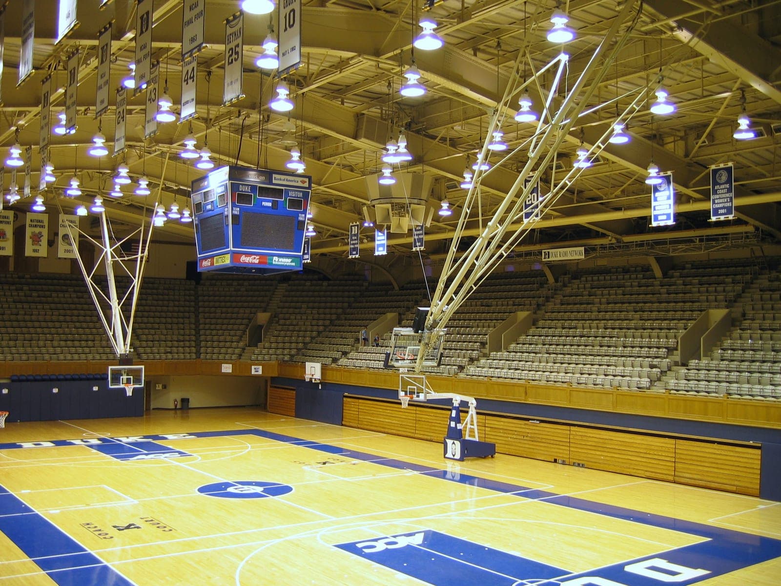 The court, hoops and stands of an indoor basketball arena.